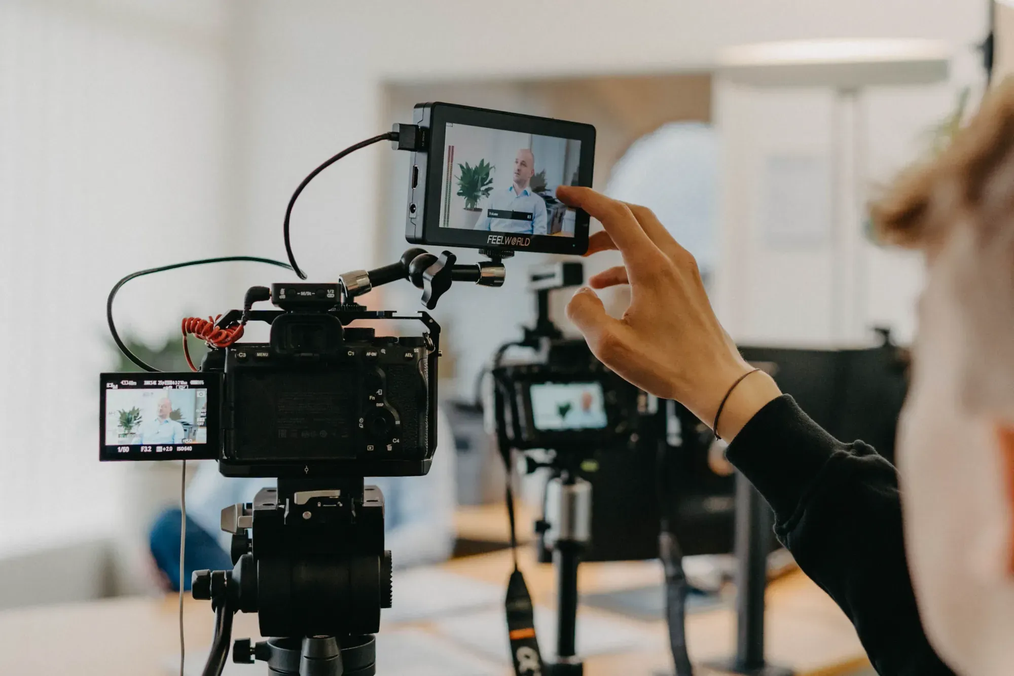 K&R behind the scenes: hand adjusting a monitor on a video camera