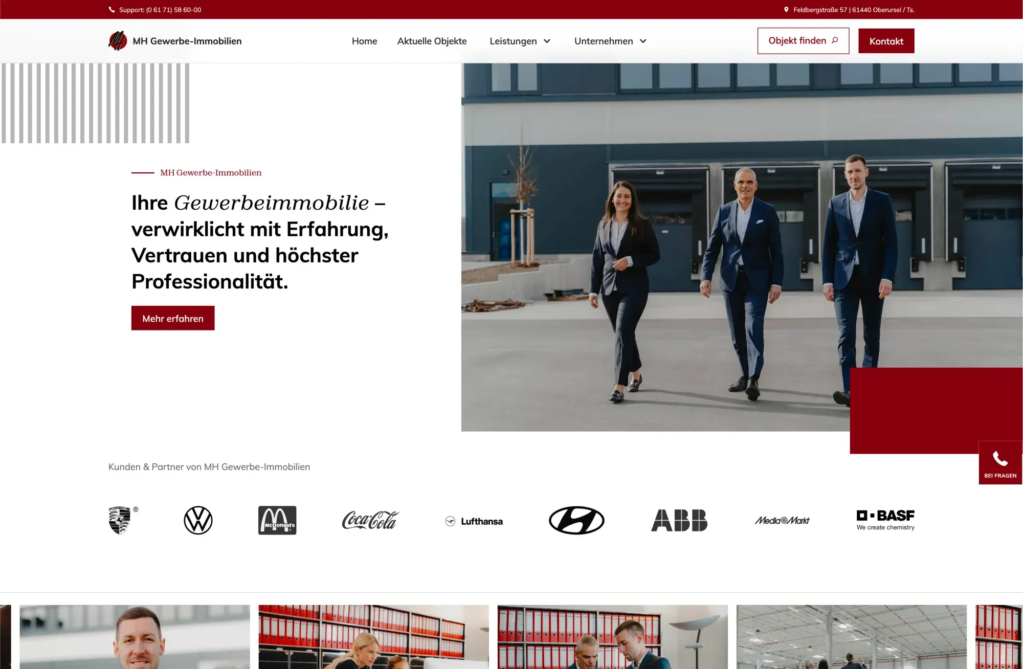 Three business people in suits walking in front of a modern commercial building.