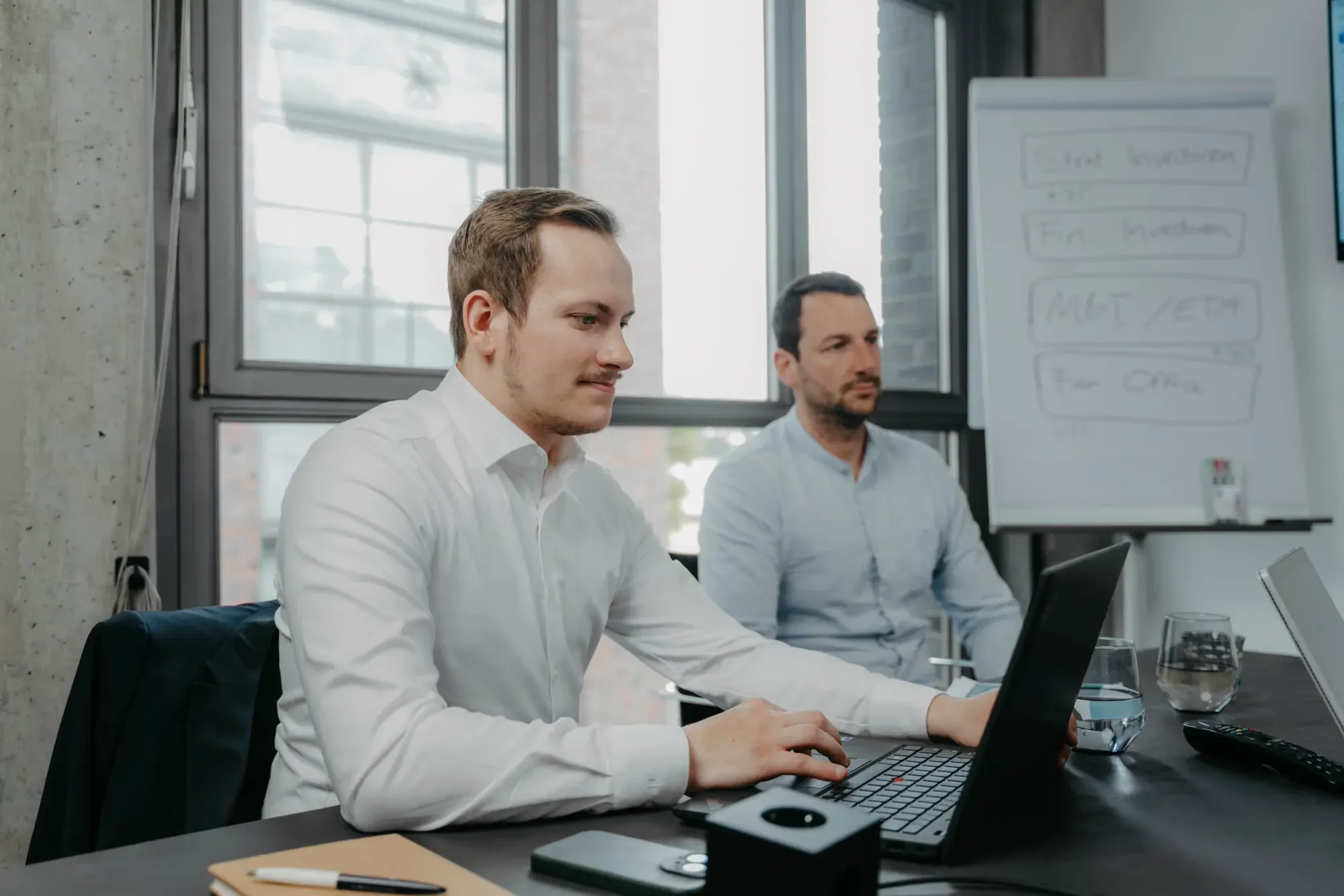 VAP team: two men working on a laptop with coffee in the modern office