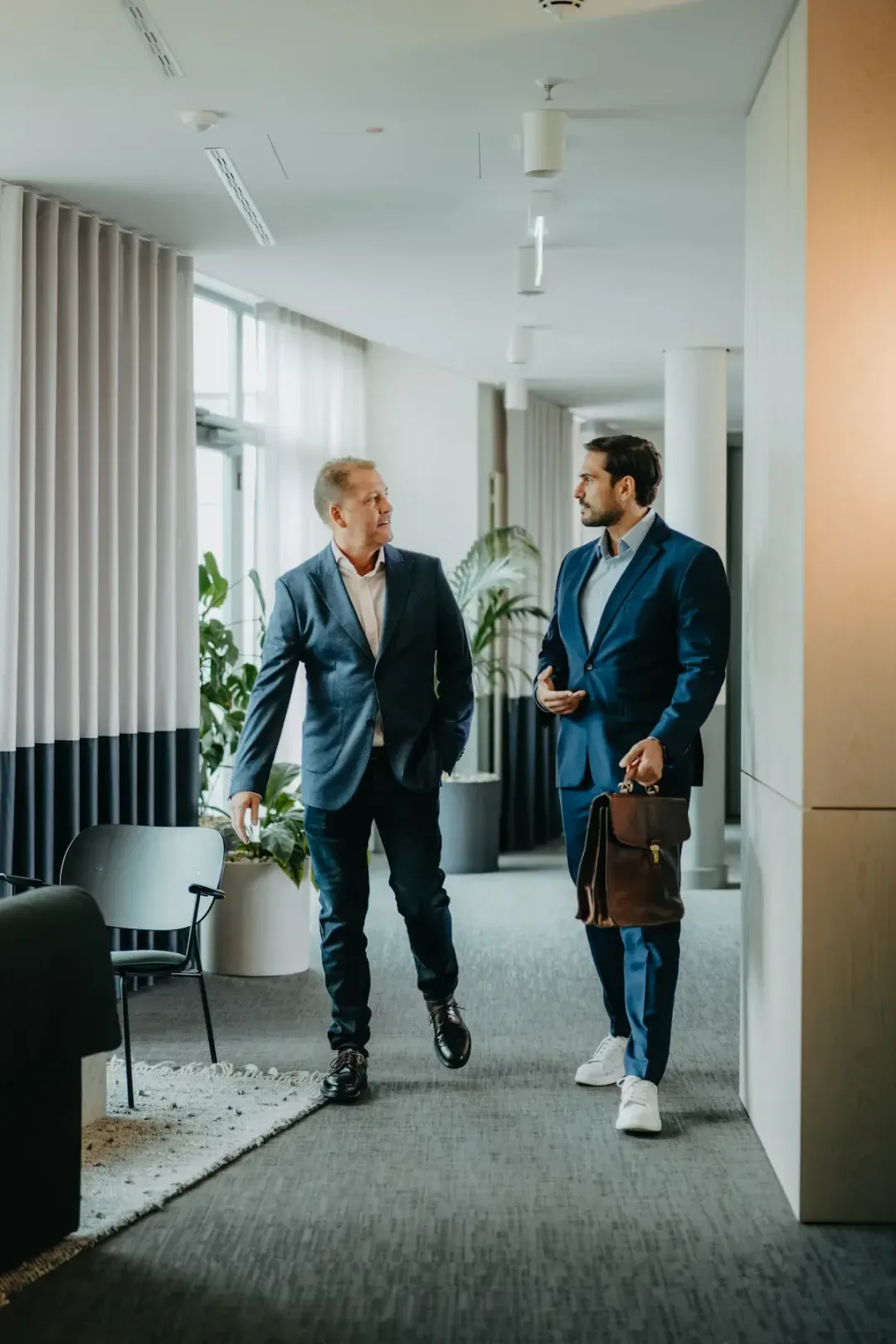 proQtech team: two businessmen walking through a modern office
