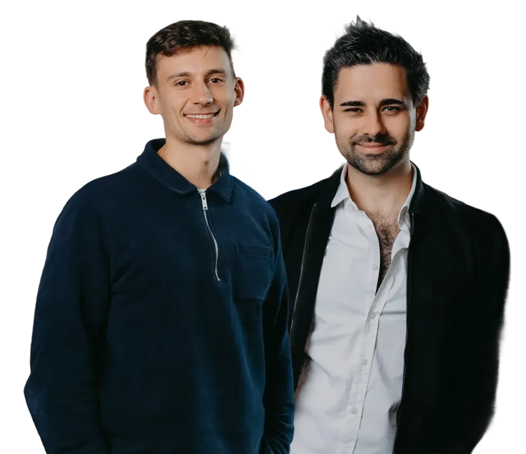 Two smiling men, one in a dark blue sweater, the other in a white shirt and black jacket.