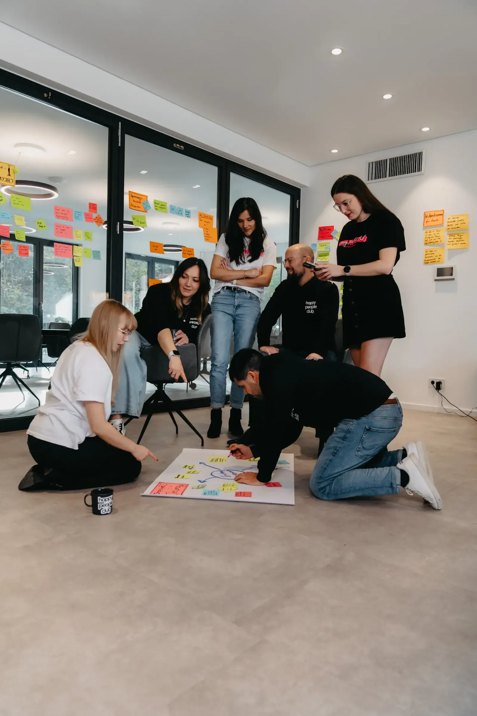 hppyppl workshop: team working with sticky notes on the floor in a modern office