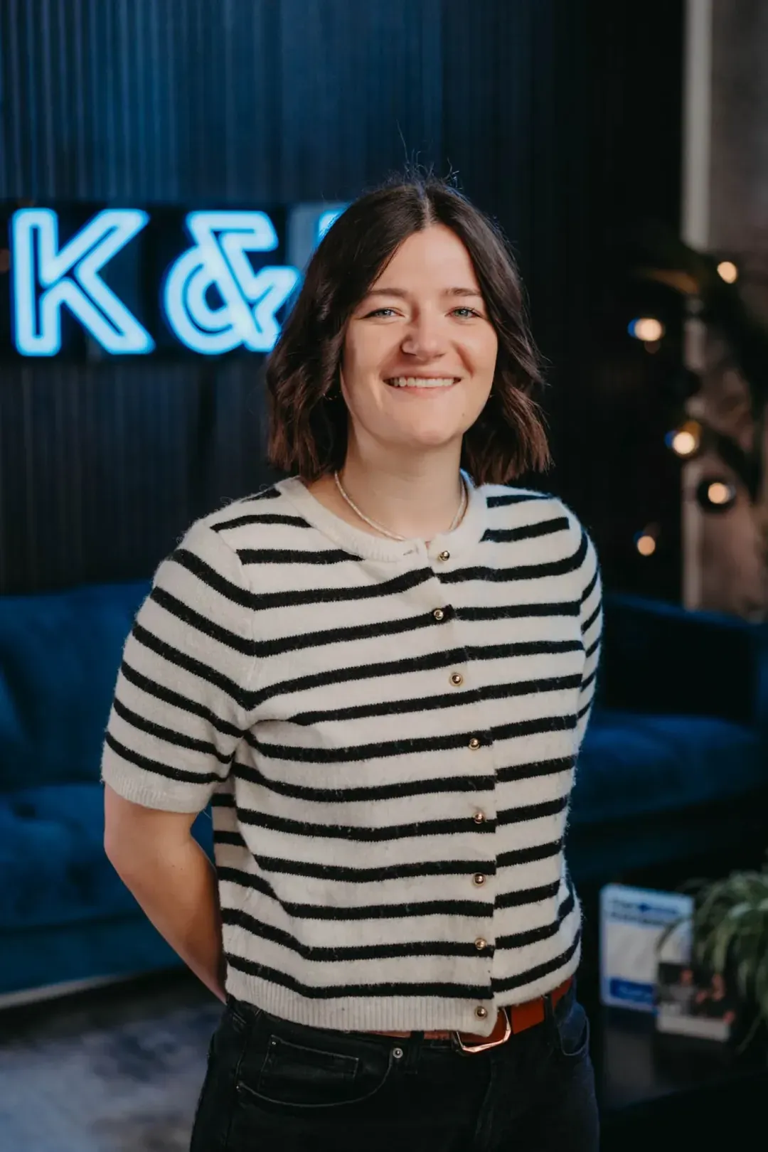 Laechelnde Frau in gestreiftem Cardigan – Business Portrait von K&R