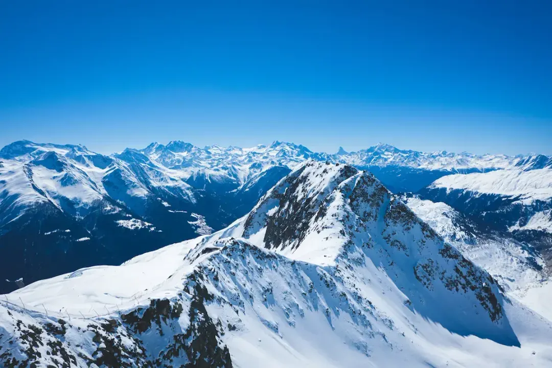 Verschneite Berggipfel der Alpen unter klarem blauem Himmel