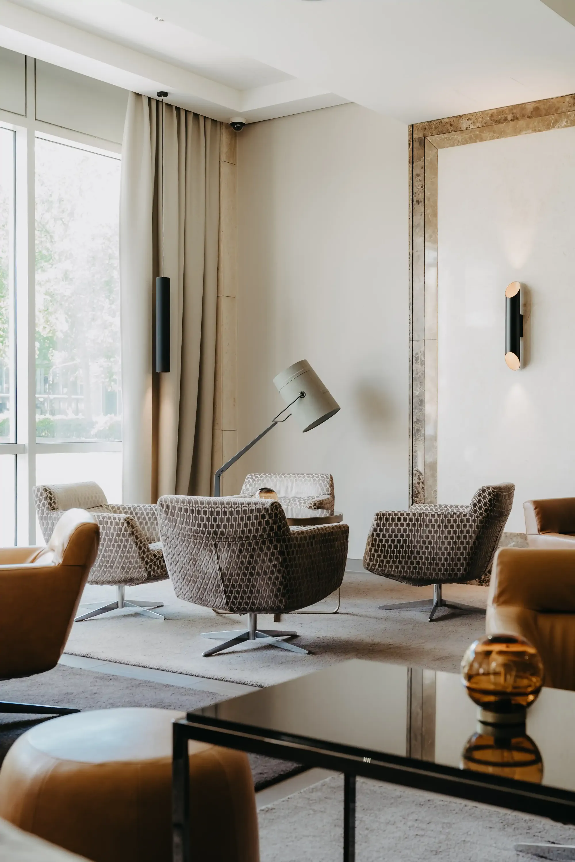 Lounge mit gemusterten Drehsesseln und goldgerahmtem Spiegel – Steigenberger Köln