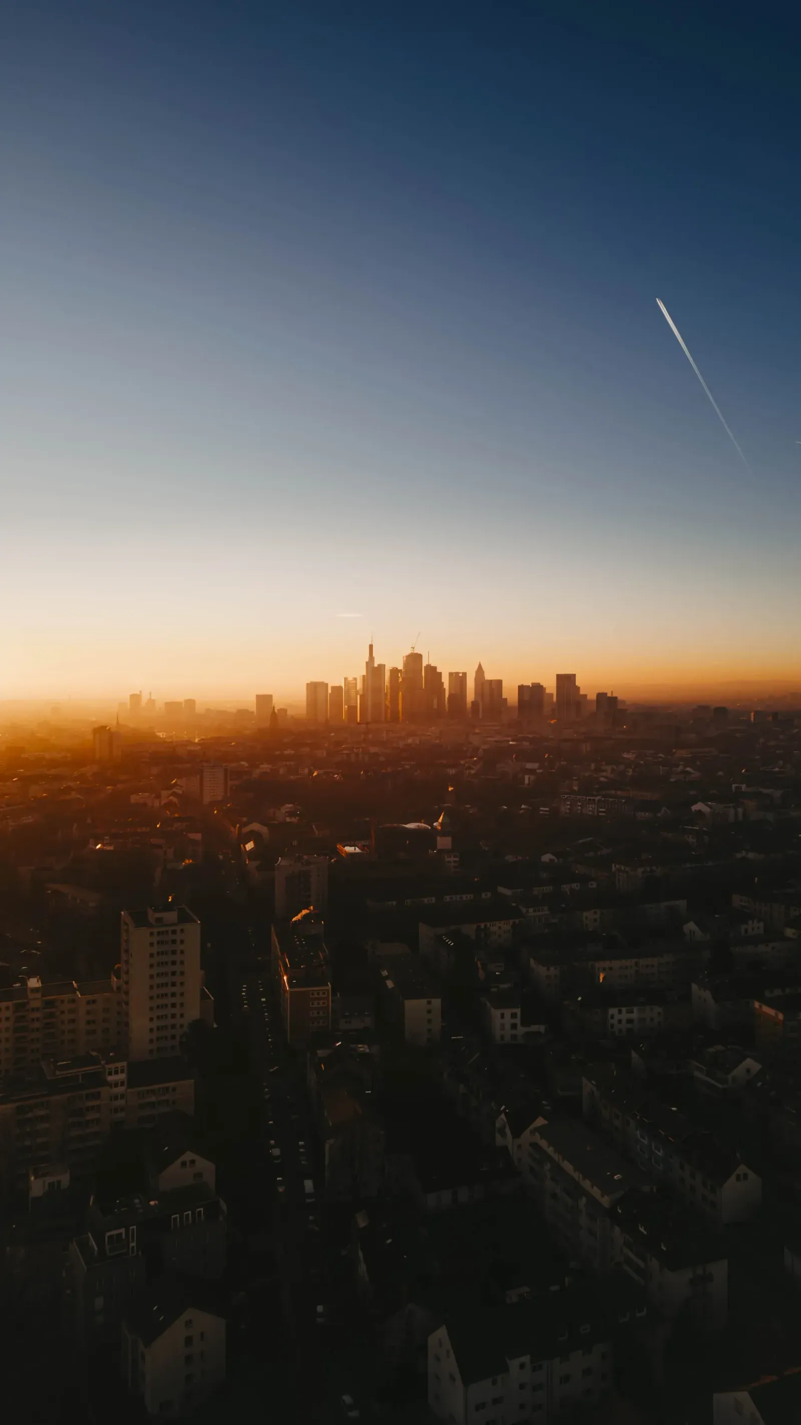 Frankfurter Skyline im Morgennebel mit Kondensstreifen – Blick vom Ostend